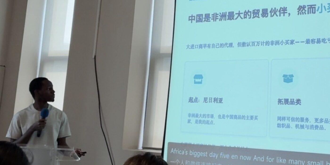 Youman's founder speaking at a business event in China, presenting "How he helps African businesses buy from China Safely".