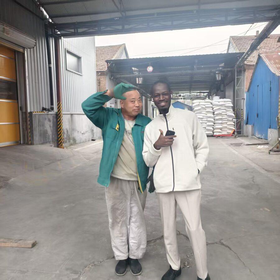 Youman with a production worker at the entrance of a Chinese supplier's plant.